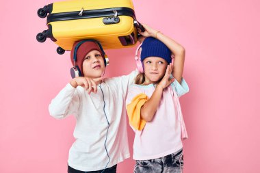 neşeli erkek ve kız sarı bavul kulaklıklar izole edilmiş arka plan