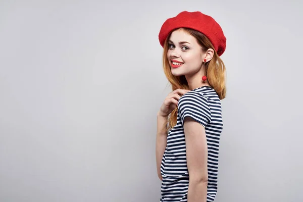 붉은 모자를 쓰고 있는 쾌활 한 여자, 프랑스 유럽 패션은 배경을 밝게 한다 — 스톡 사진
