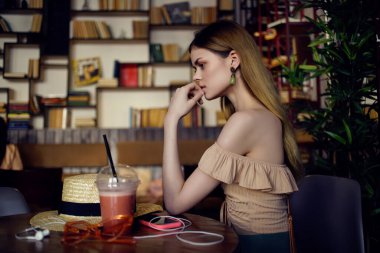 Kafe iletişiminde içki içen neşeli bir kadın.