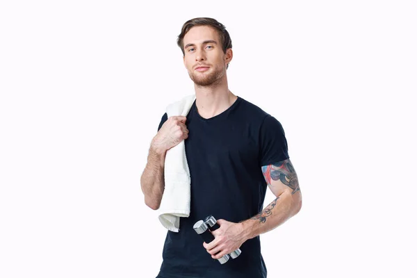 Homem de esportes em uma camiseta preta com halteres em suas mãos exercícios de fitness — Fotografia de Stock