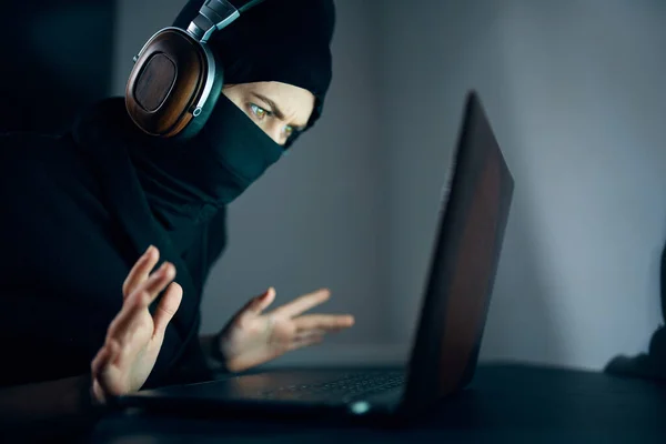 Mujer con máscara delante de la piratería de auriculares portátiles — Foto de Stock