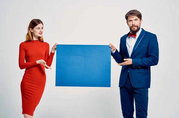 Homme en costume à côté de la femme en robe rouge affiche mocap bleu — Photo