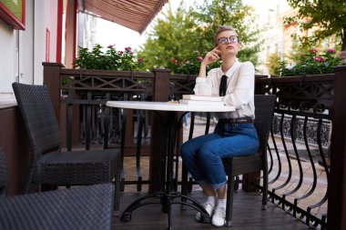 Elinde kitap olan bir öğrenci temiz hava iletişiminde yürüyor.