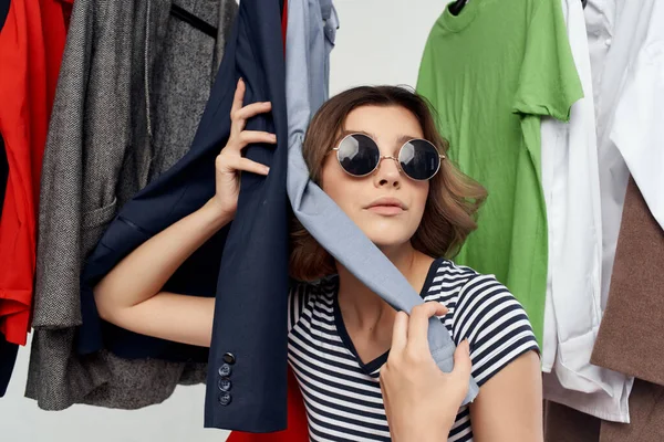 Donna allegra Shopaholic scegliere vestiti shopping in negozio sfondo luce — Foto Stock