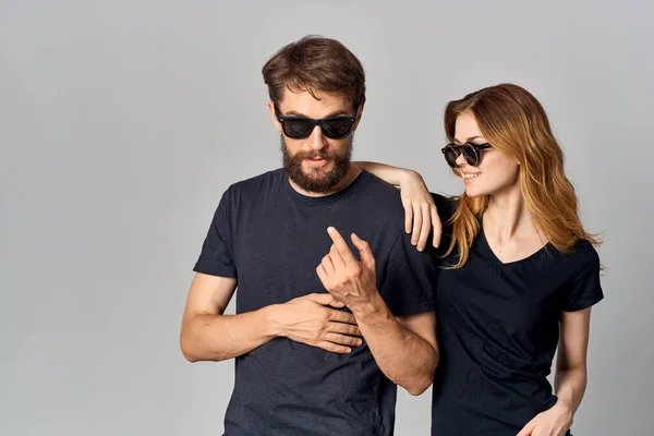 Homem e mulher na moda em preto t-shirt óculos de sol posando fundo isolado — Fotografia de Stock