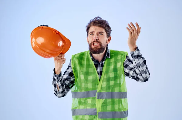 Uomo di lavoro in arancio costruzione cappello duro professionale sfondo blu — Foto Stock