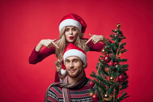 Homem e mulher Natal árvore decoração diversão feriado vermelho fundo — Fotografia de Stock