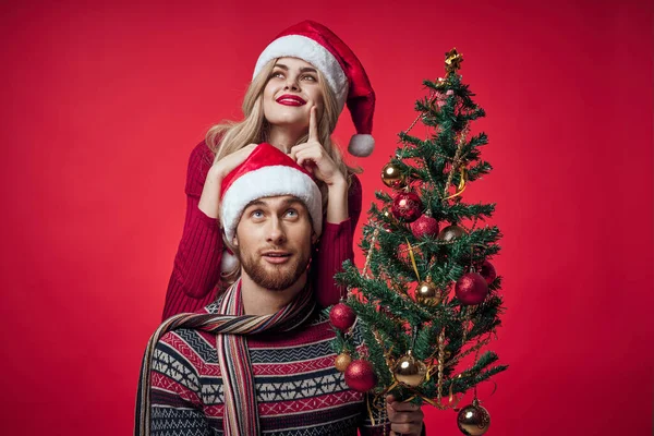 Ung gift par julgran leksaker semester glädje röd bakgrund — Stockfoto