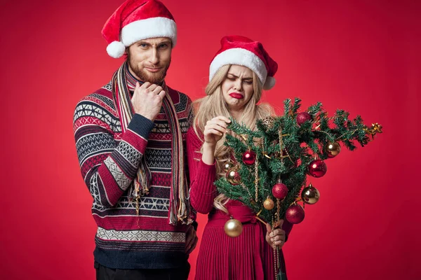 Homem e mulher Natal brinquedos feriado decoração vermelho fundo — Fotografia de Stock