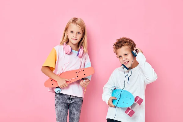 Divertido niño y niña monopatines auriculares estilo de vida —  Fotos de Stock