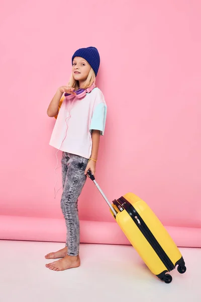 女の子でA青帽子スタイリッシュな服スーツケースポーズ — ストック写真