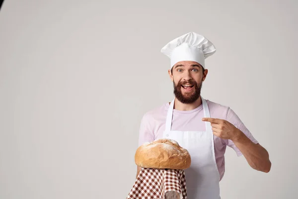 Önlüklü adam taze ekmek pişiriyor. — Stok fotoğraf