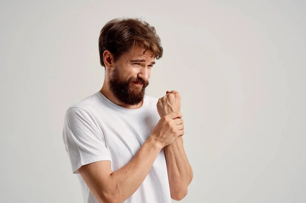 Чоловік у білій футболці проблеми зі здоров'ям руки — стокове фото