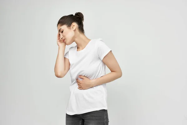 Brunette in white t-shirt abdominal pain medicine treatment — Stock Photo, Image