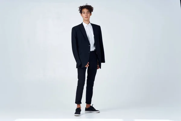 Man met krullend haar en een zwarte jas mode — Stockfoto
