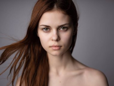 Güzel kadın saç stili, çıplak omuzlar, açık ten rengi, koyu renk arka plan.