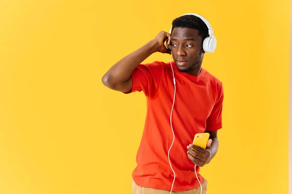 Moda afro-americano usando fones de ouvido música entretenimento fundo amarelo — Fotografia de Stock