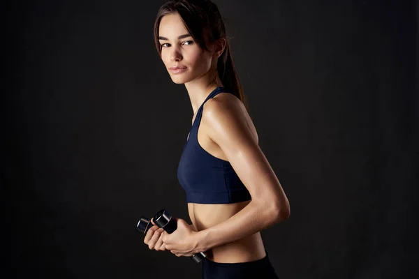 Atletische vrouw met halters in de hand met workout oefeningen studio gym — Stockfoto