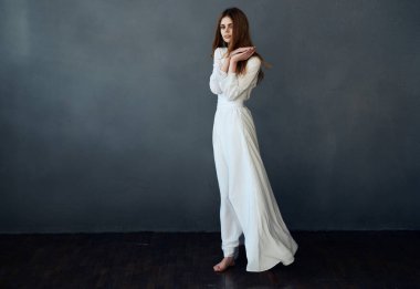 Beyaz elbiseli çekici kadın saç stili performansı sergiliyor.