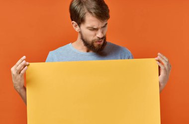 Komik adam reklam yapıyor. Fotokopi alanı turuncu arka planı.