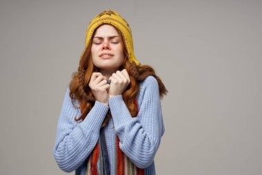 Hasta kadın boyun atkısı ve arka planında şapka var.