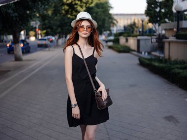 Yazın açık havada poz veren şapkalı güzel bir kadın.