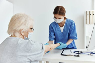Yaşlı kadın ve doktor hastane muayenehanesini ziyaret etti