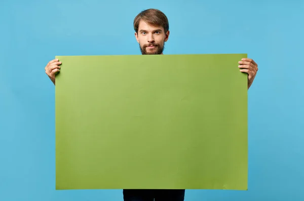 푸른 배경을 광고하는 데 사용되는 수염을 기른 사람의 녹색 종이 — 스톡 사진