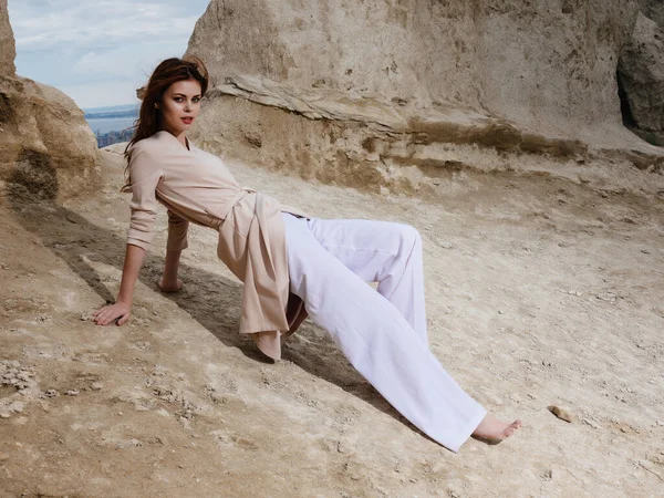 Schöne Frau sitzt auf dem Sand eleganten Stil — Stockfoto