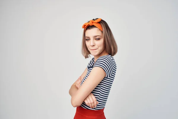 Mujer en rayas camiseta naranja diadema emociones fondo claro —  Fotos de Stock