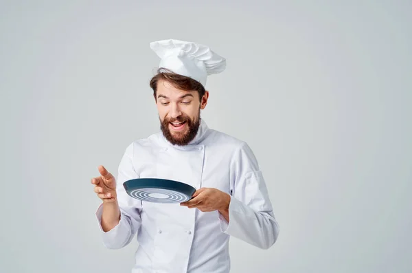 Un uomo in un cuochi uniforme cucina utensili lavoro isolato sfondo — Foto Stock