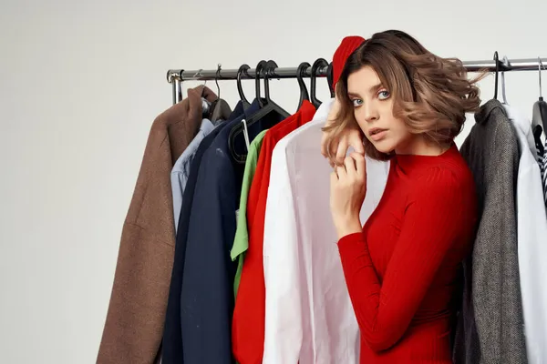 Giysilerin yanında neşeli bir kadın moda perakendecisi izole edilmiş arka plan — Stok fotoğraf