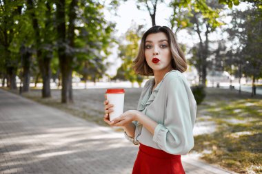 Kırmızı etekli güzel bir kadın. Eğlenceli bir yaz yürüyüşü.