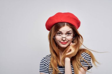 Çizgili tişörtlü güzel bir kadın. Kırmızı dudaklar. Elleriyle yaşam tarzını gösteriyor.