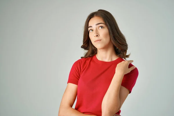 Vacker kvinna i en röd t-shirt hårvård isolerad bakgrund — Stockfoto