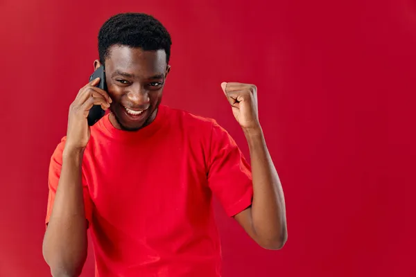 Homem de aparência africana falando ao telefone em um fundo isolado — Fotografia de Stock