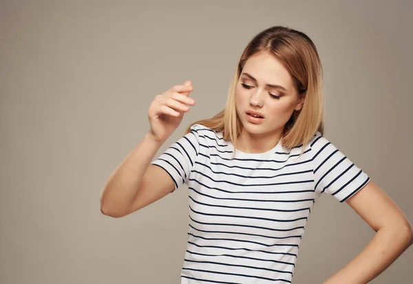 Ξανθό κορίτσι σε ριγέ t-shirt συγκινήσεις στούντιο δυσαρέσκειας — Φωτογραφία Αρχείου