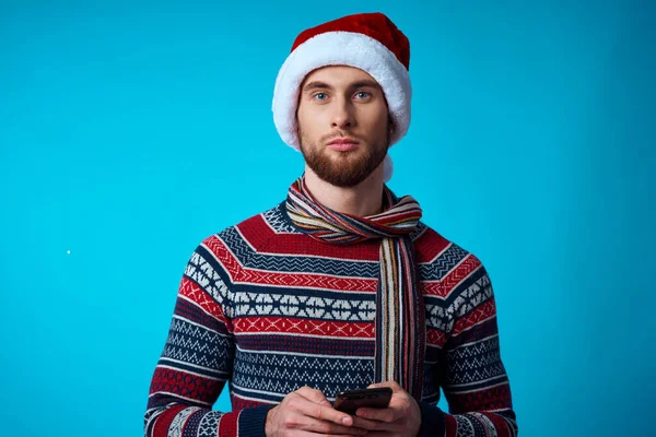 Wesoły człowiek z telefonem w ręku świąteczne święta technologia niebieskie tło — Zdjęcie stockowe