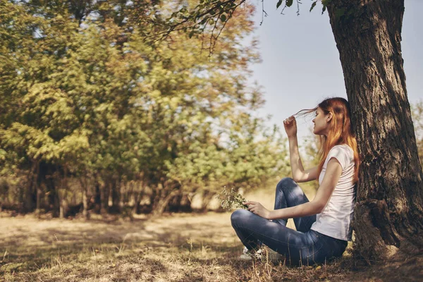 Bonita mujer sentada cerca de un árbol Aire fresco —  Fotos de Stock