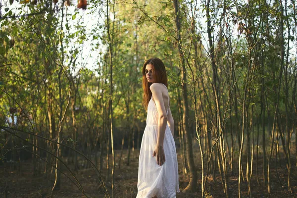 Vacker kvinna i vit klänning promenader i skogen natur vila — Stockfoto