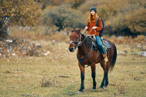 Woman hiker riding a horse on nature travel — Stock Photo, Image