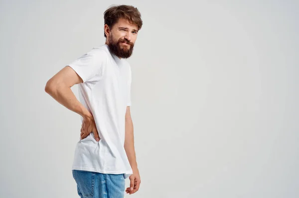 Brodaty mężczyzna w białym t-shirt lek stres pleców lekkie tło — Zdjęcie stockowe
