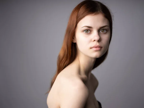 Mujer con hombros desnudos modelo de peinado posando fondo aislado —  Fotos de Stock