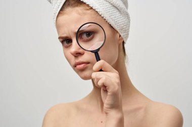 Elinde büyüteçle cilt sorunları olan güzel bir kadın.