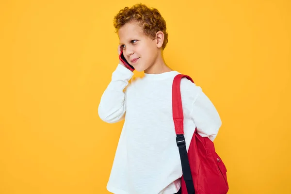 Leende liten pojke använda telefonen utbildning barn livsstil gul bakgrund — Stockfoto
