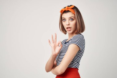 Kafasında bandajla yakın çekim pozu veren çizgili tişörtlü bir kadın.