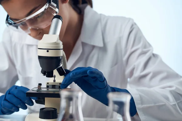 Kvinnliga läkare kemiska lösningar biolog forskning studera ljus bakgrund — Stockfoto