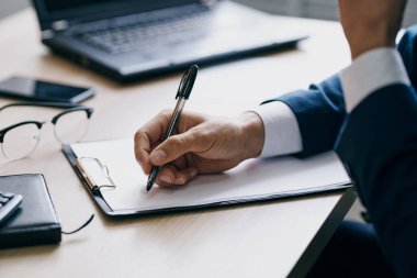 Bir dizüstü bilgisayarın önünde oturan sakallı bir adam.