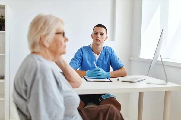 Een oudere vrouw wordt onderzocht door een arts een bezoek aan het ziekenhuis — Stockfoto