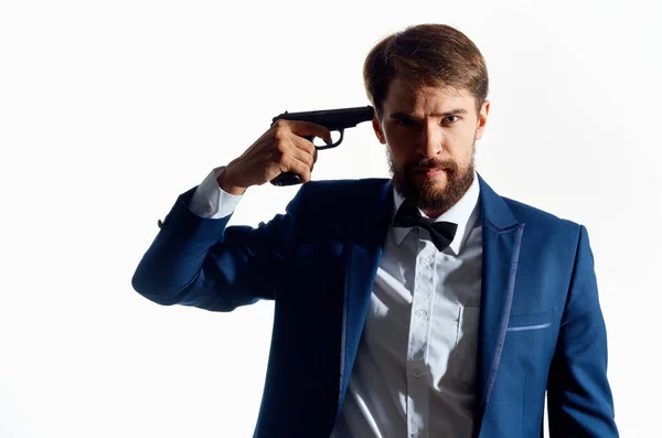 Mann im Anzug mit Pistole in der Hand heller Hintergrund — Stockfoto